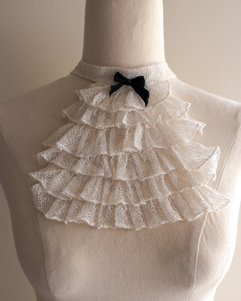 White lace jabot with a black bow on a mannequin