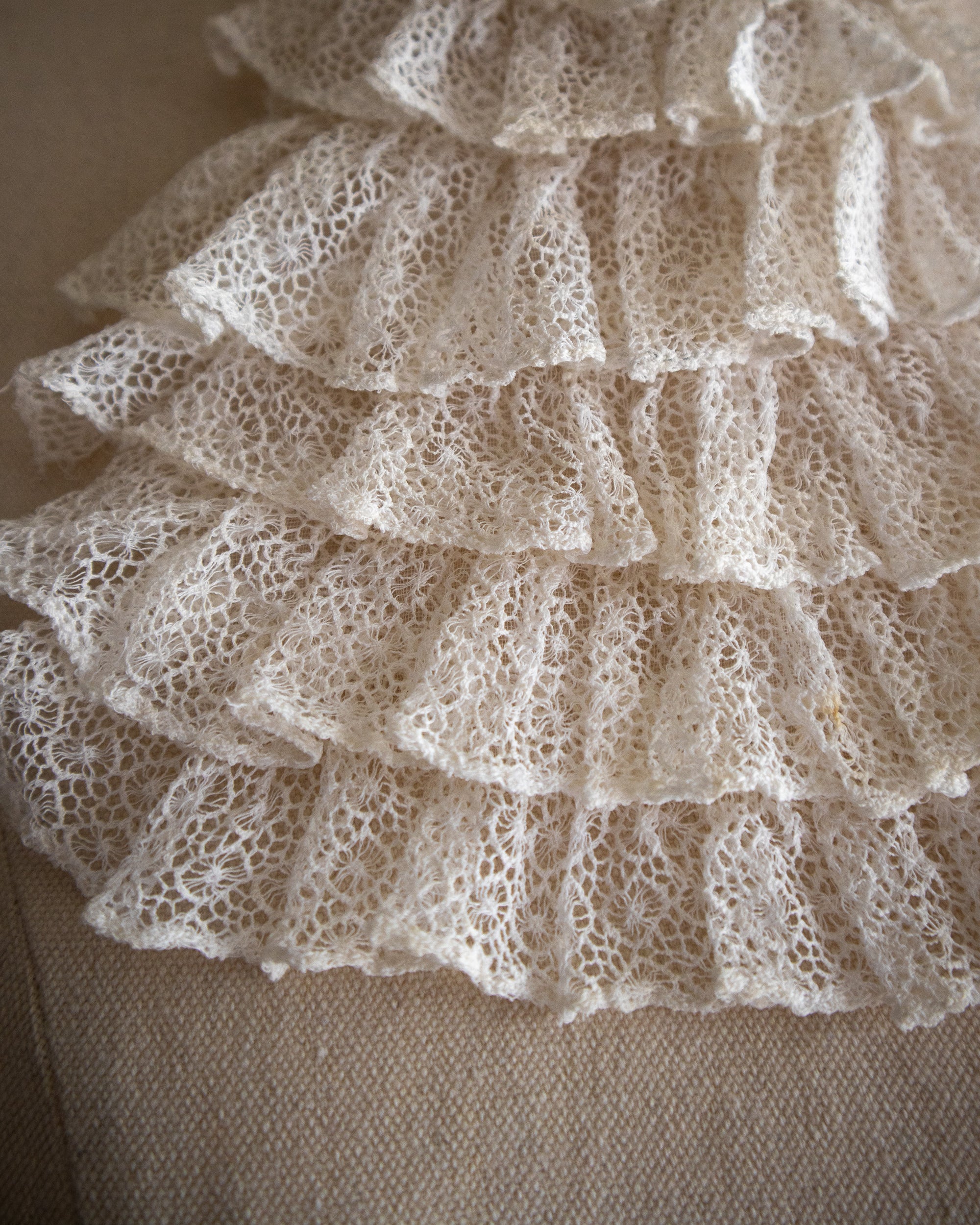 Close-up of lace fabric with ruffled edges on a neutral background