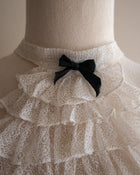 Mannequin wearing a lace jabot with a black bow