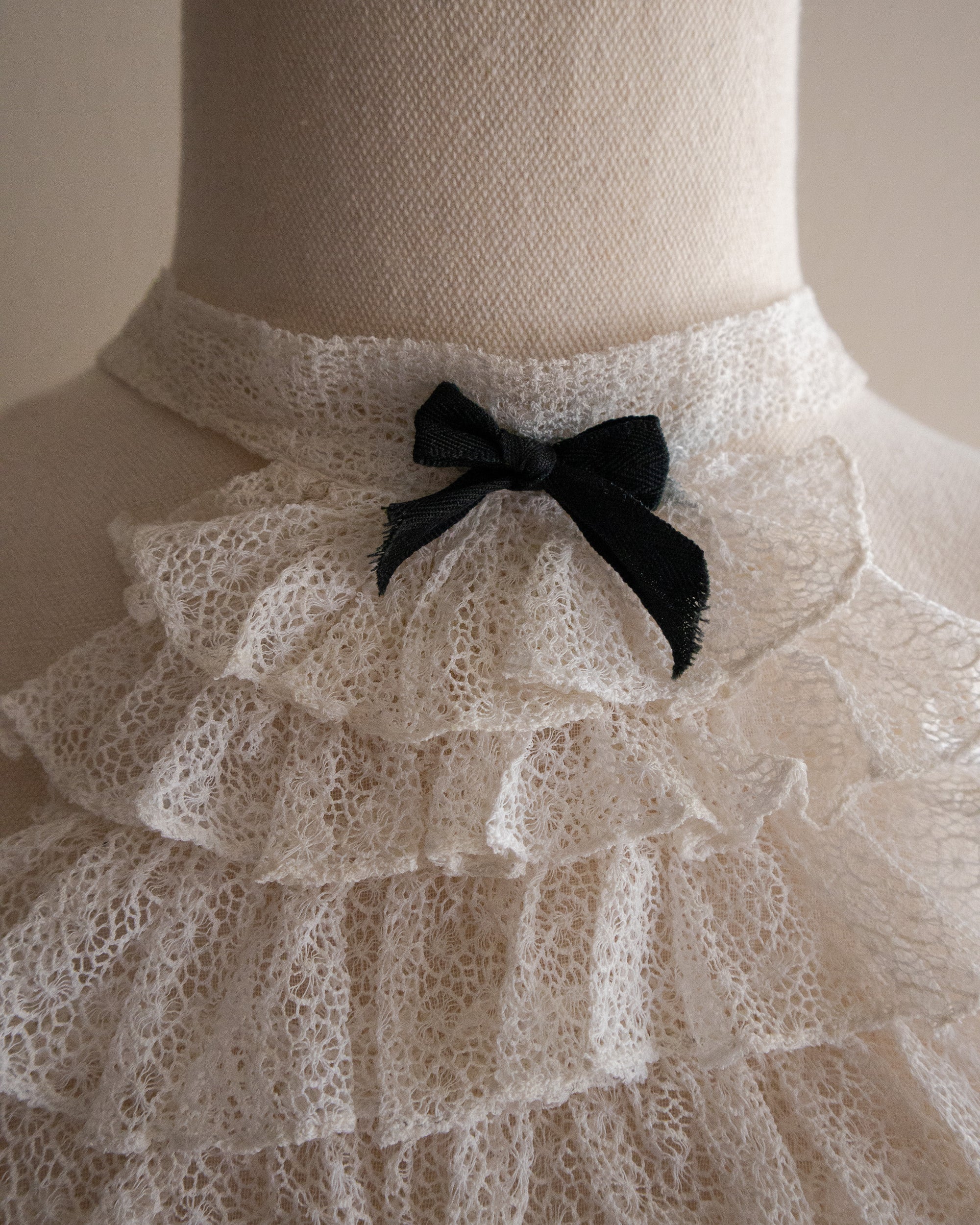 Mannequin wearing a lace jabot with a black bow