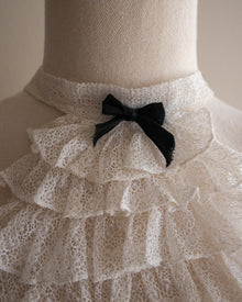 Mannequin wearing a lace jabot with a black bow