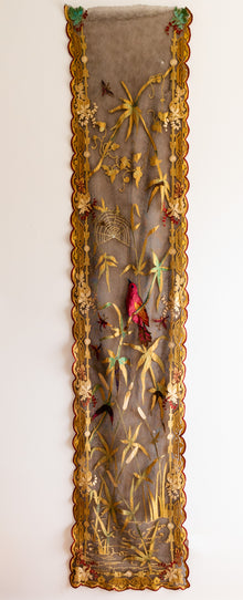 Decorative panel with gold frame and embroidered details on a white background