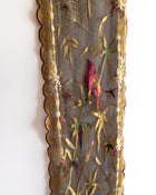 Decorative panel with embroidered bird, flowers, and spider web on a white background