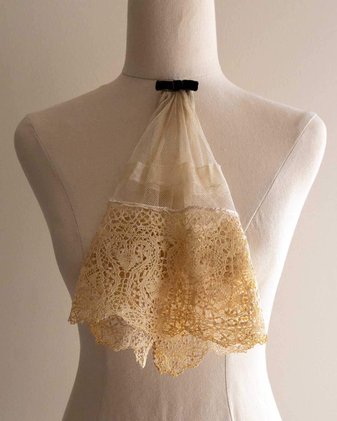 Lace jabot on a mannequin against a neutral background