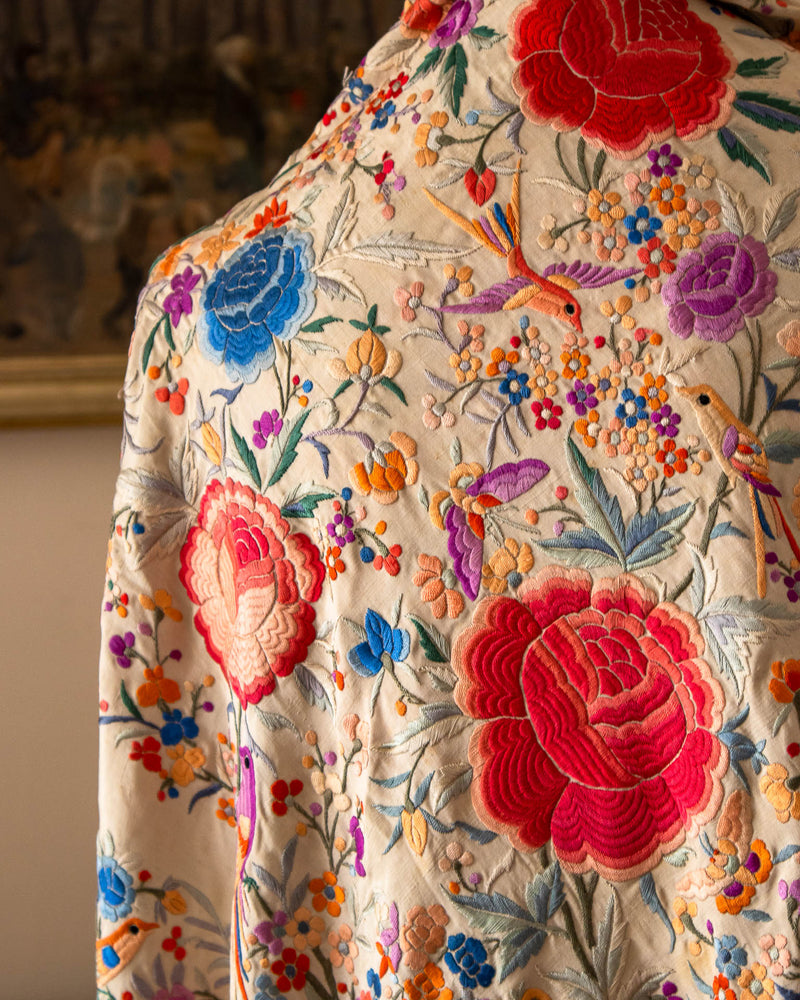Close-up of a scarf with intricate floral and bird embroidery.
