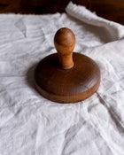 Wooden butter stamp on a white fabric background