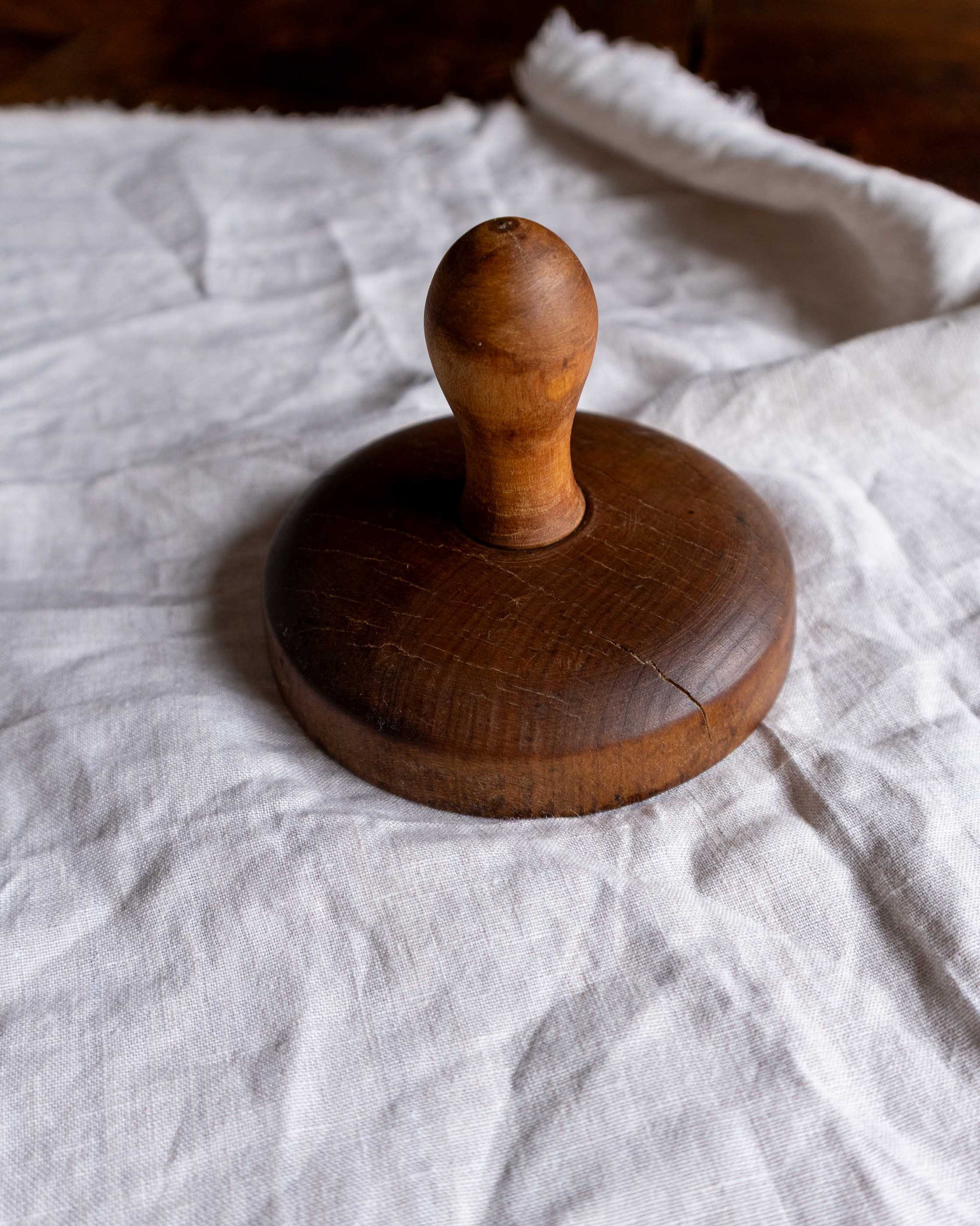 Wooden butter stamp on a white fabric background