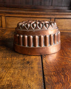 Copper mold with decorative patterns on a wooden surface