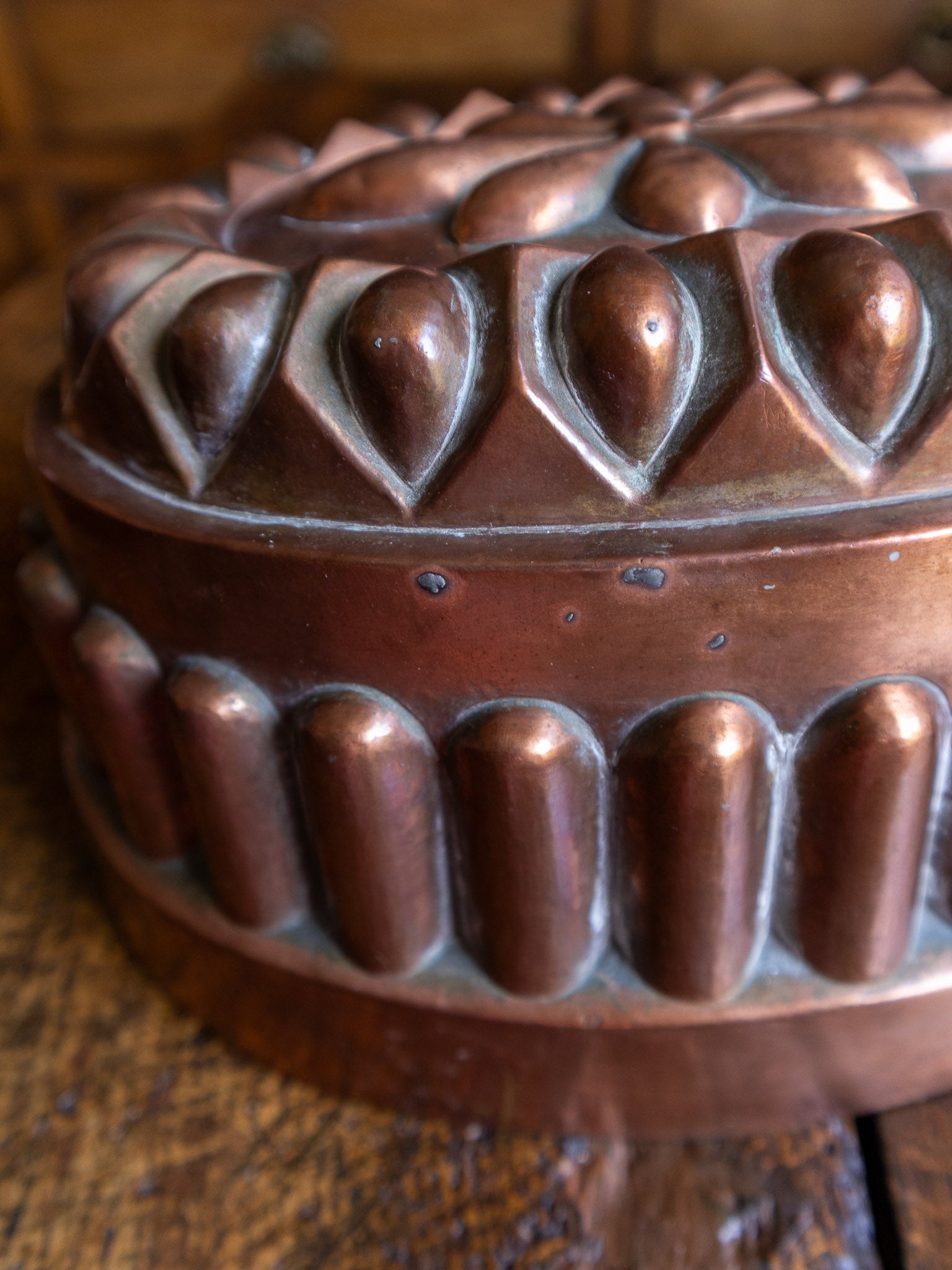 Copper mold with intricate design on a wooden surface