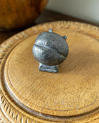 Decorative wooden breadboard with a pewter mould on a dark background