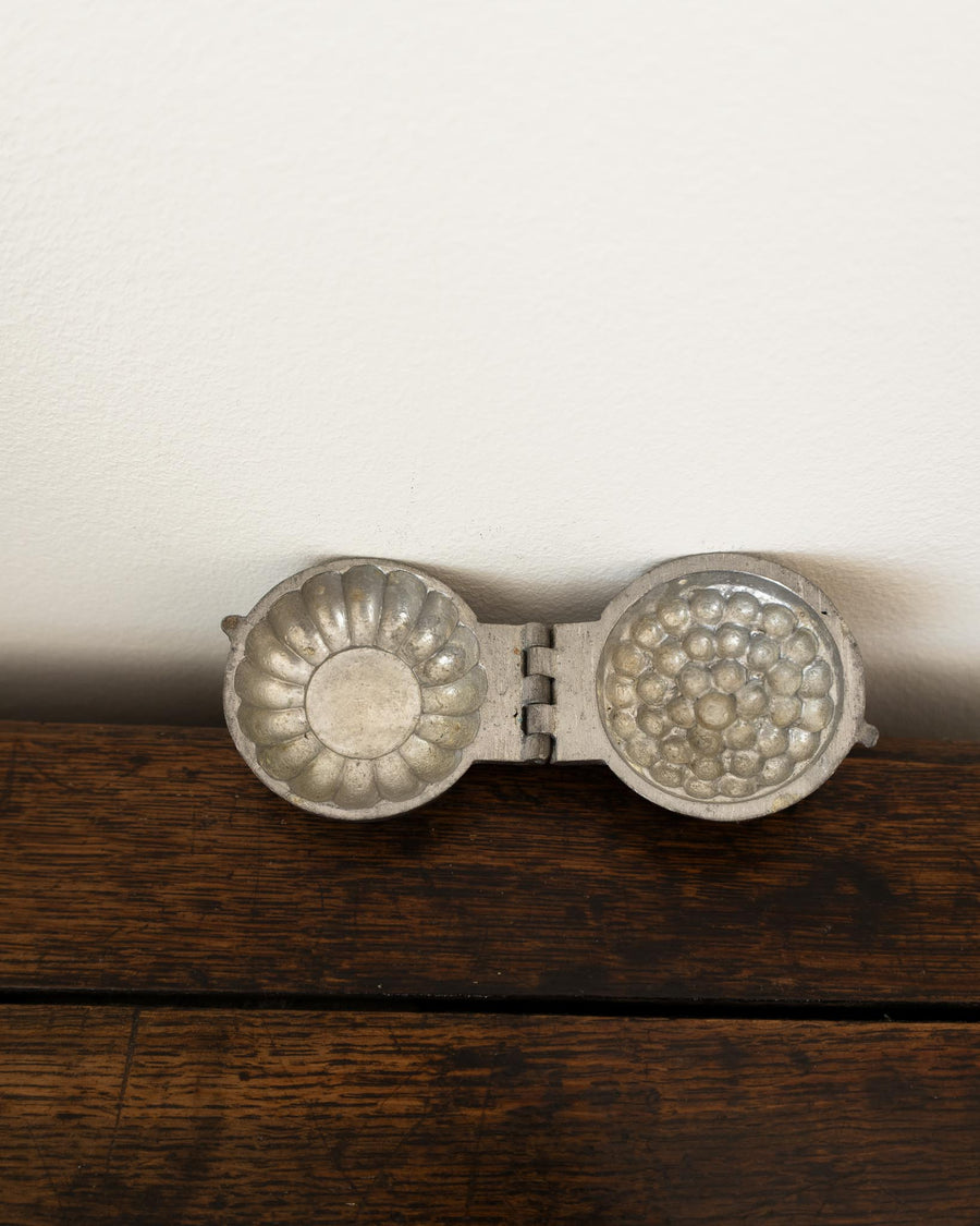 Decorative pewter mould on a white background