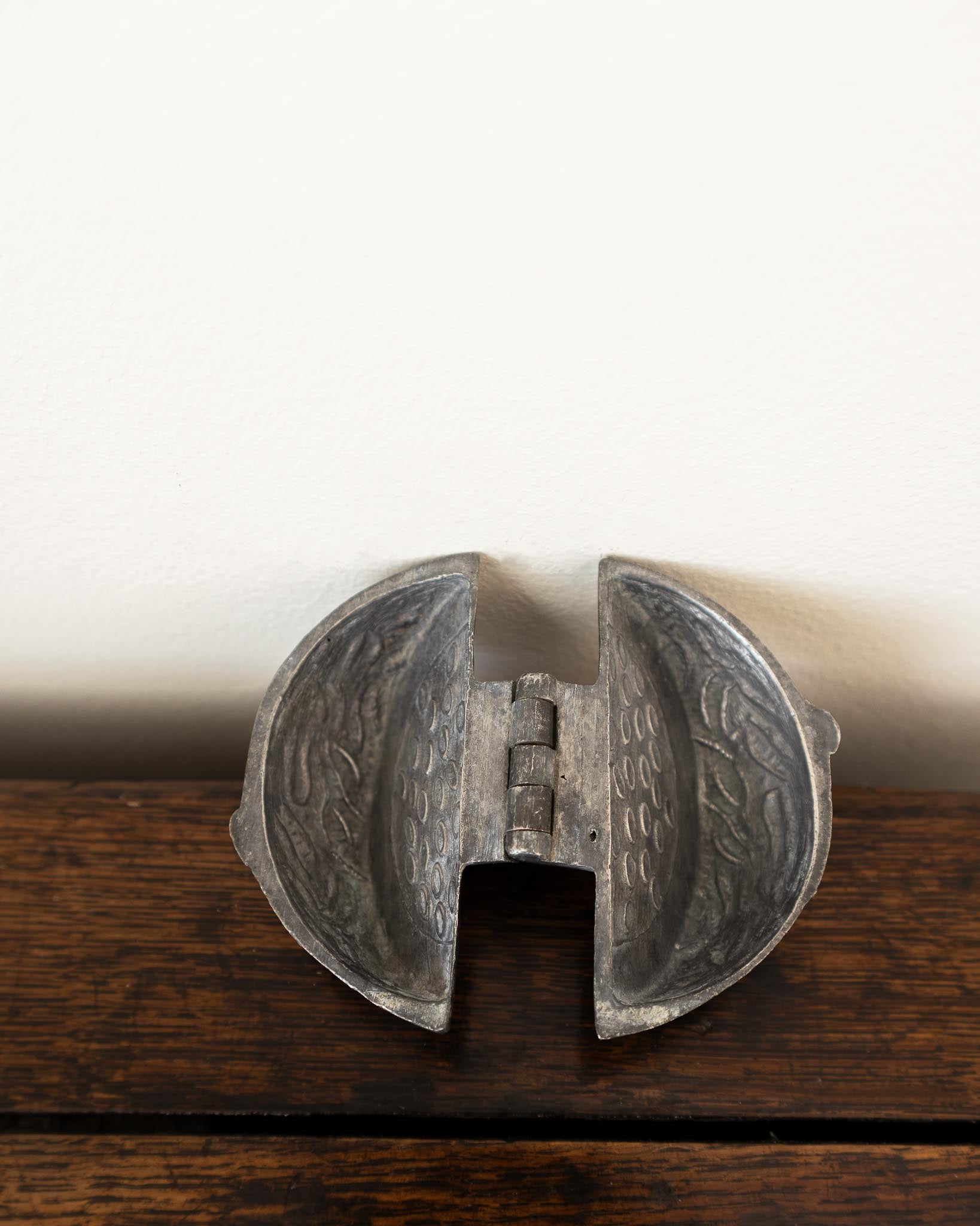 Decorative pewter mould on a white background