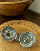Decorative breadboard with a pewter mould on a wooden surface