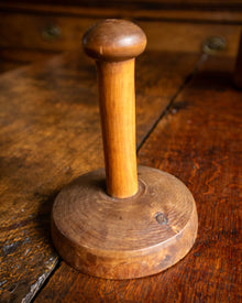 Wooden butter stamp handle on a wooden surface