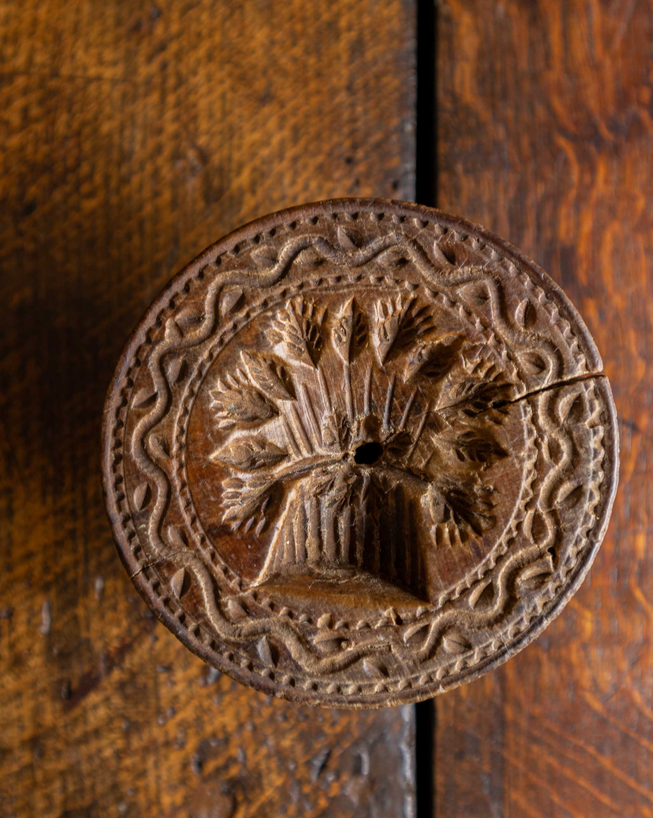 Decorative wooden stamp with intricate design on a wooden surface