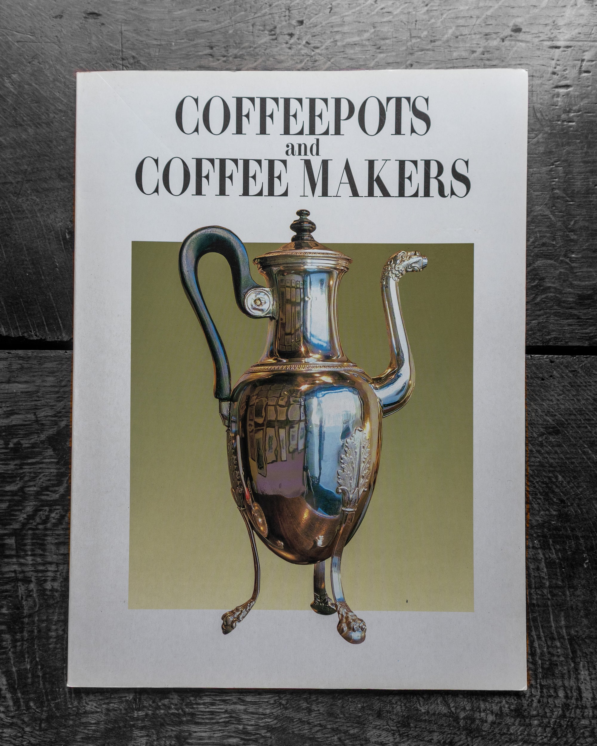 Book cover titled 'Coffeepots and Coffee Makers' with an illustration of a silver coffee pot on a wooden surface.