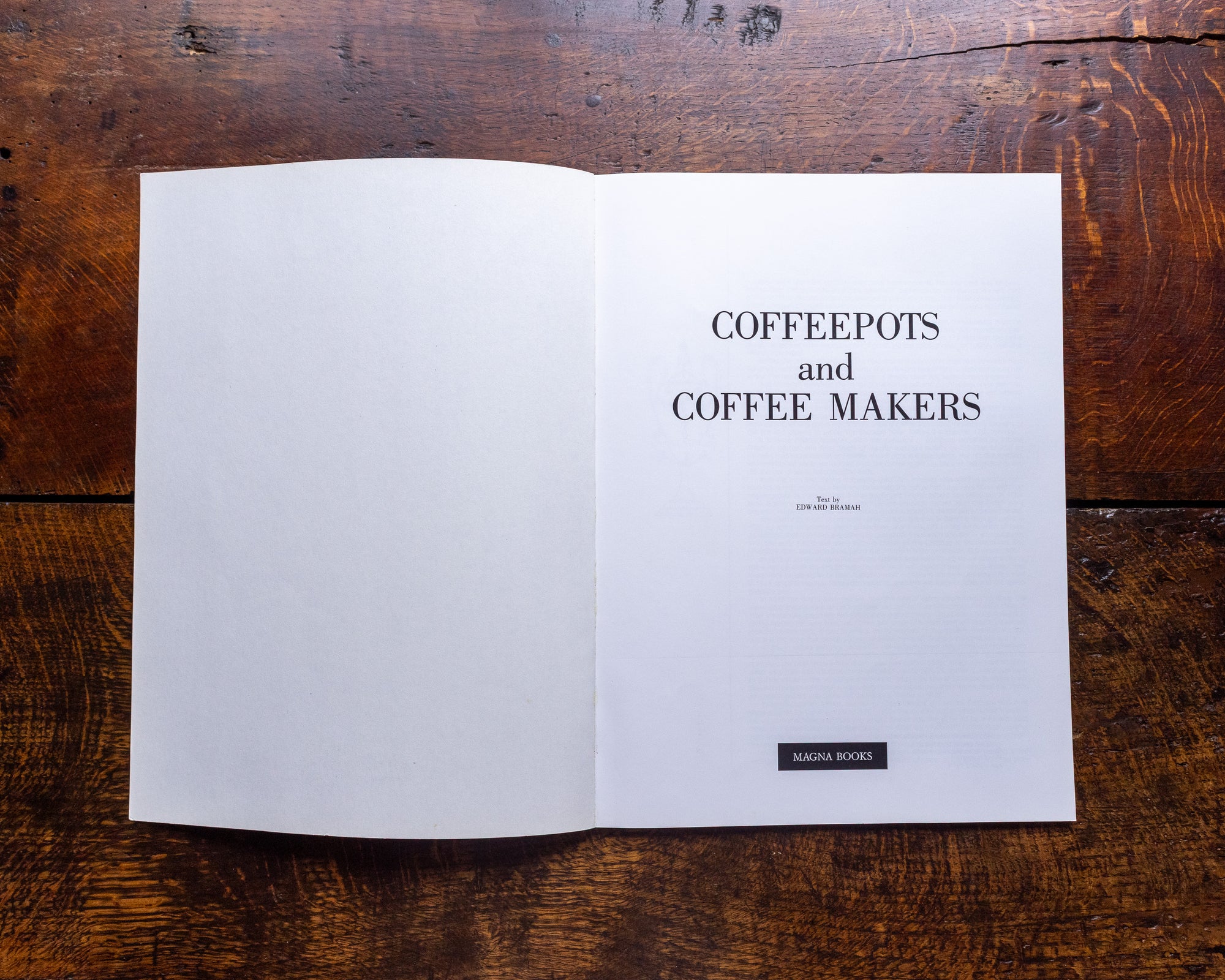 Open book on a wooden surface with text 'COFFEEPOTS and COFFEE MAKERS'.