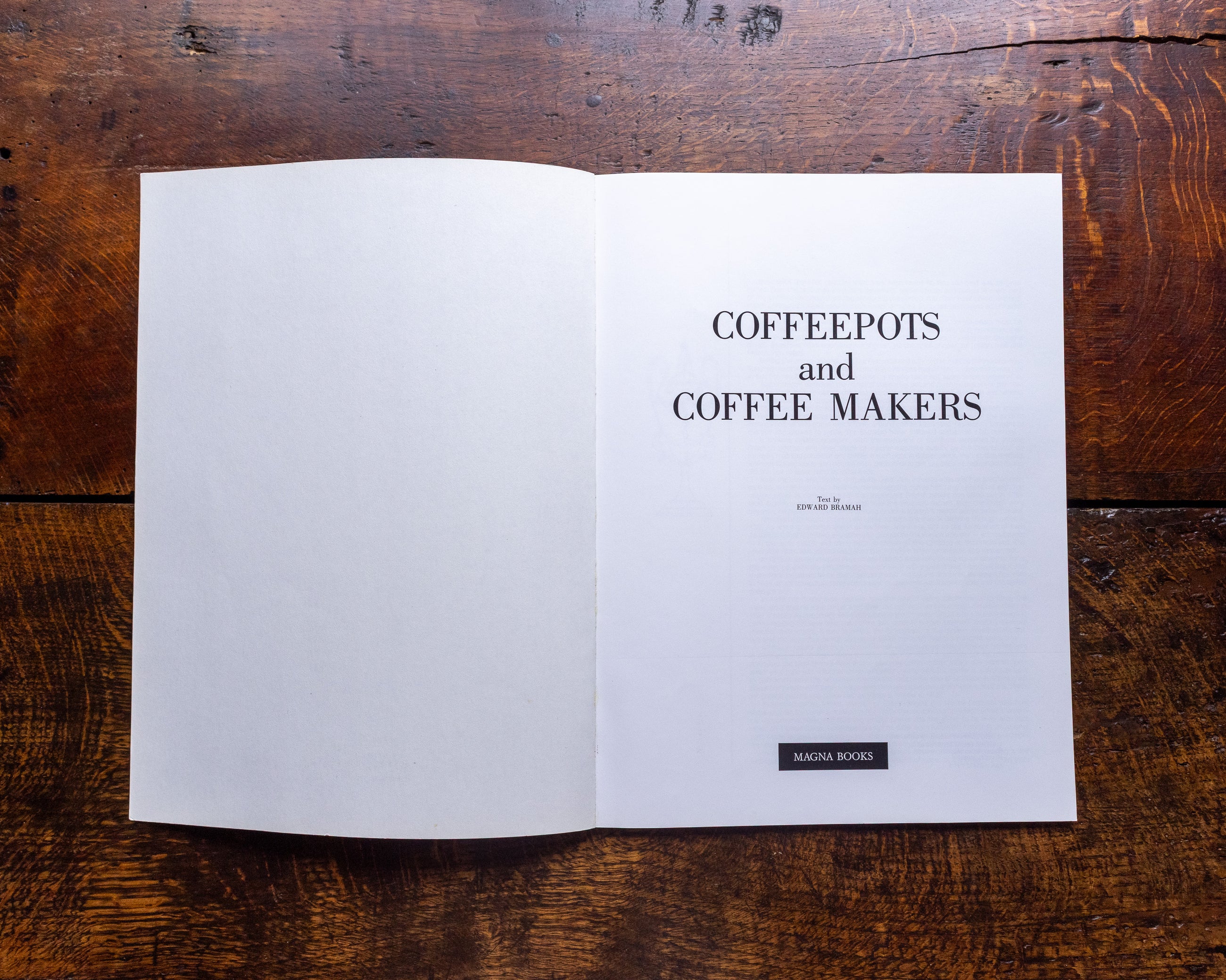 Open book on a wooden surface with text 'COFFEEPOTS and COFFEE MAKERS'.