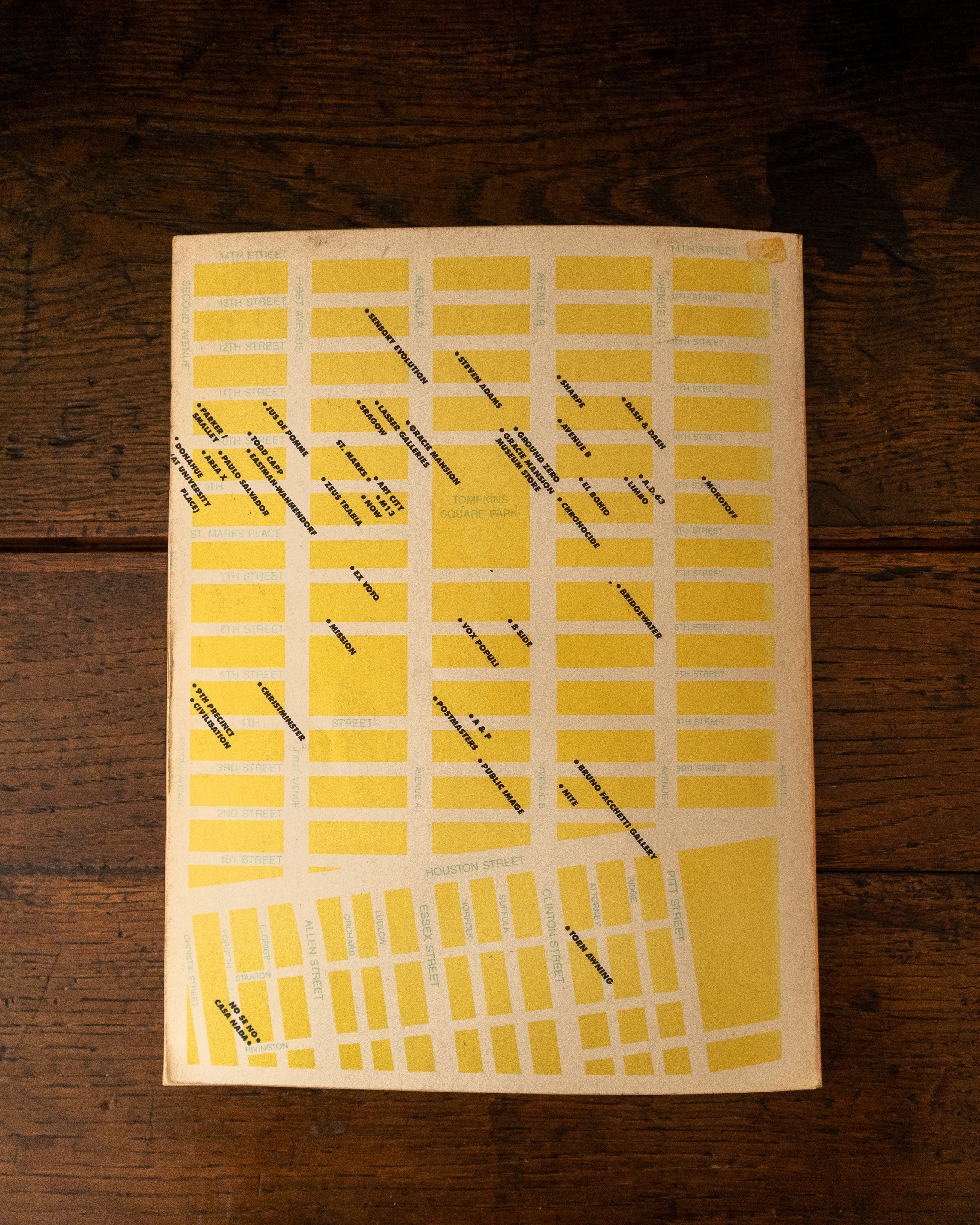 Back cover of 'Eastvillage' with illustration on a wooden background