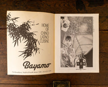 Open book with illustrations and text on a wooden surface