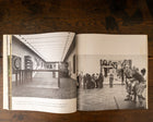 Open book showing black and white photographs of an art gallery interior.