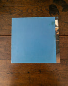 Back cover of blue book on a wooden surface.