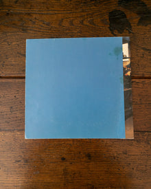 Back cover of blue book on a wooden surface.