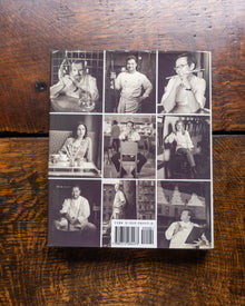 Collage of black and white images on a book cover, placed on a wooden surface.