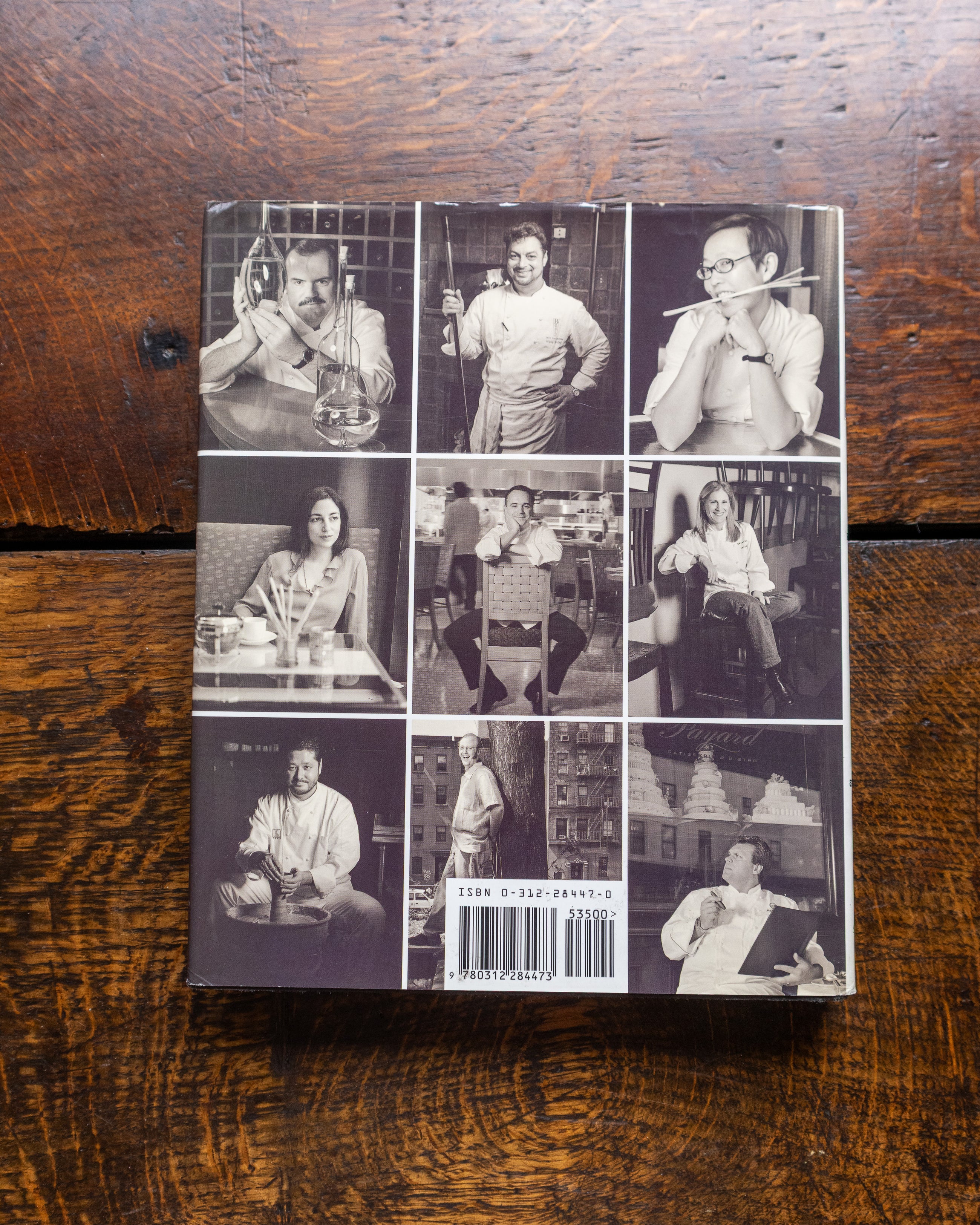 Collage of black and white images on a book cover, placed on a wooden surface.