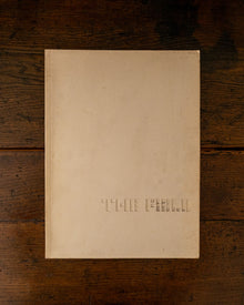 Cover book with embossed text 'The Field' on a wooden surface