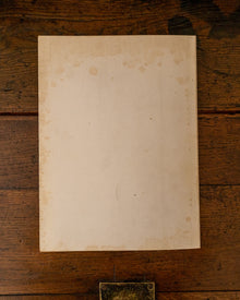 Back cover book with embossed text 'The Field' on a wooden surface