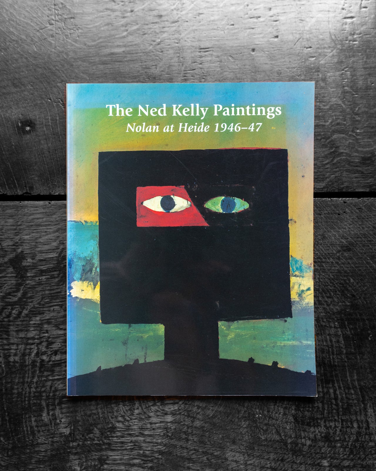 Book cover of 'The Ned Kelly Paintings' with abstract design on a textured surface