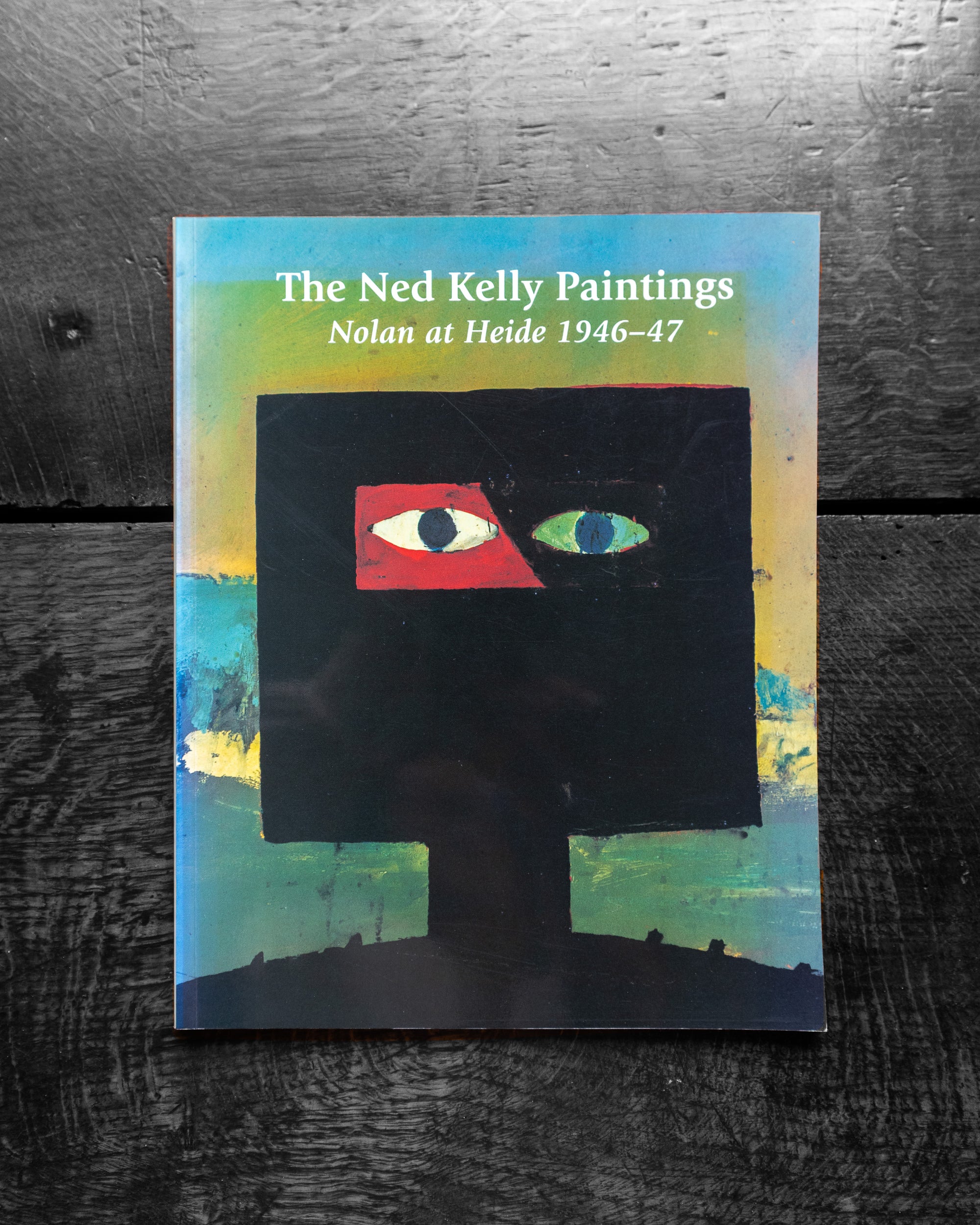 Book cover of 'The Ned Kelly Paintings' with abstract design on a textured surface