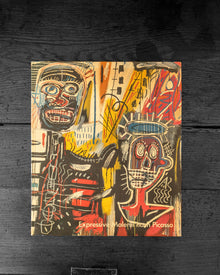 Book cover with abstract art and text 'Expressive Works by Picasso' on a dark wooden background