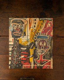 Book cover with abstract art and text 'Expressive Works by Picasso' on a wooden surface