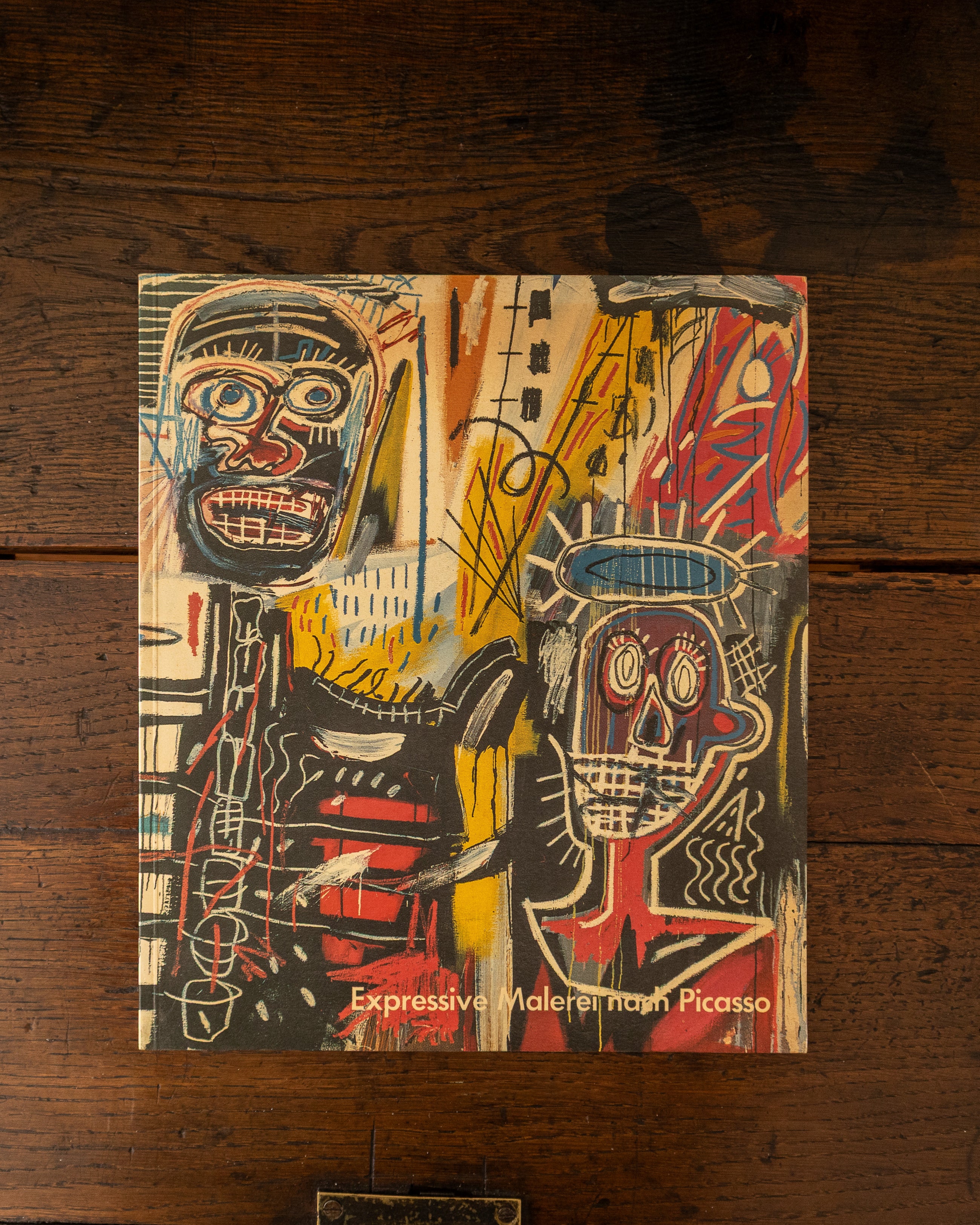 Book cover with abstract art and text 'Expressive Works by Picasso' on a wooden surface
