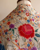 Embroidered scarf with colorful floral patterns on a mannequin.