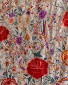 Embroidered fabric with colorful flowers and birds on a light background