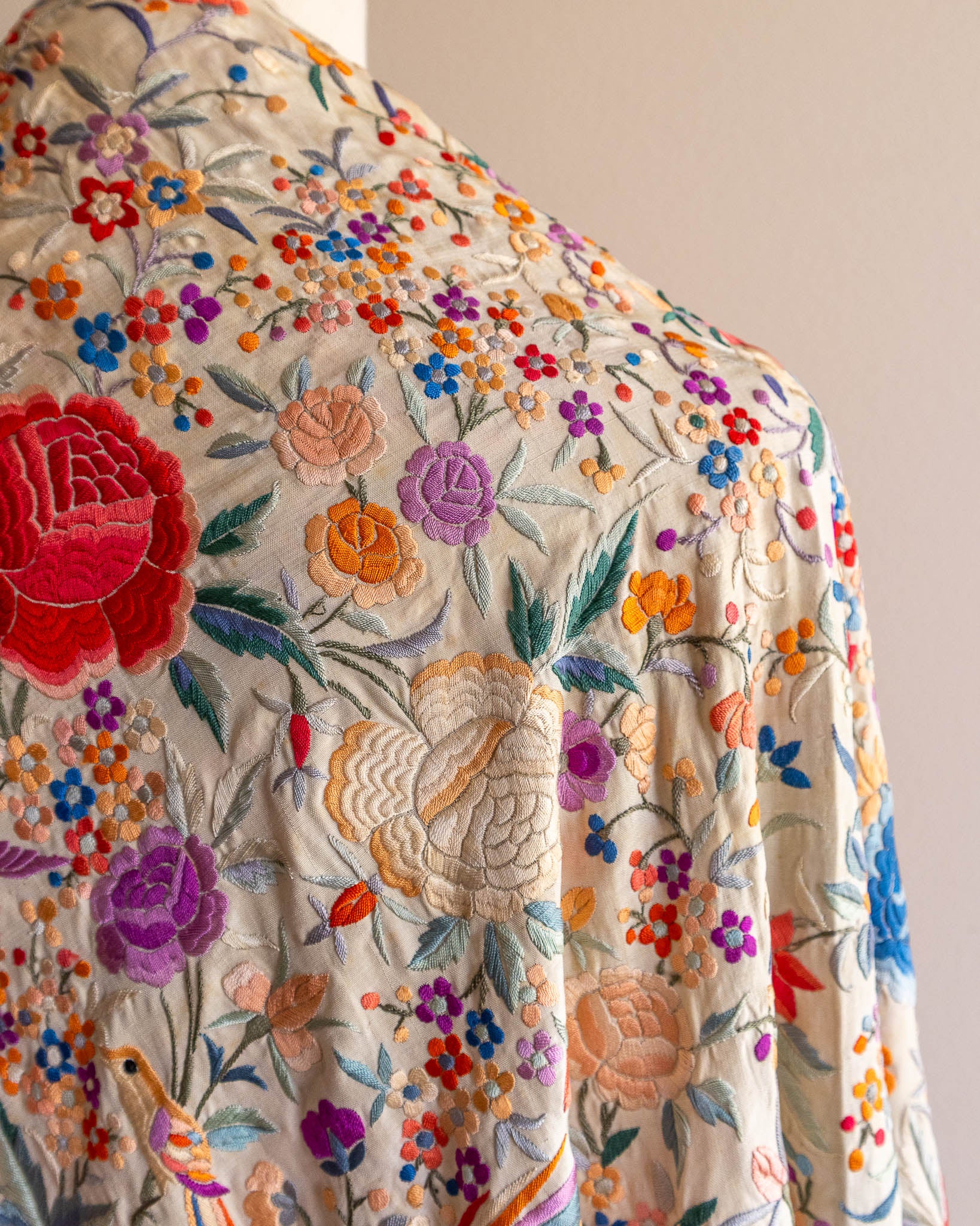 Close-up of a scarf with colorful floral embroidery on a plain background