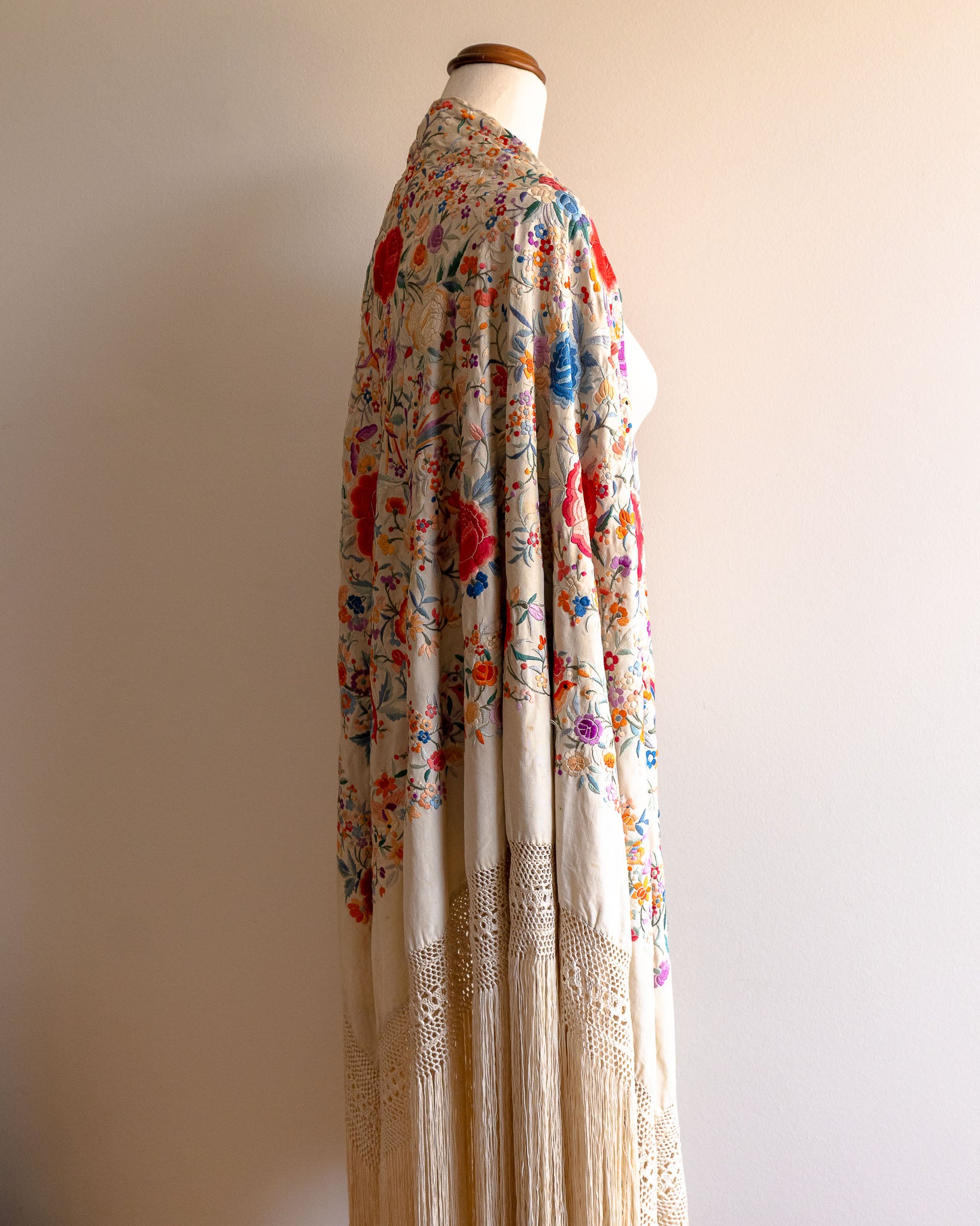 Mannequin wearing a floral scarf with a plain background