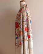 Floral patterned scarf on a mannequin against a plain background