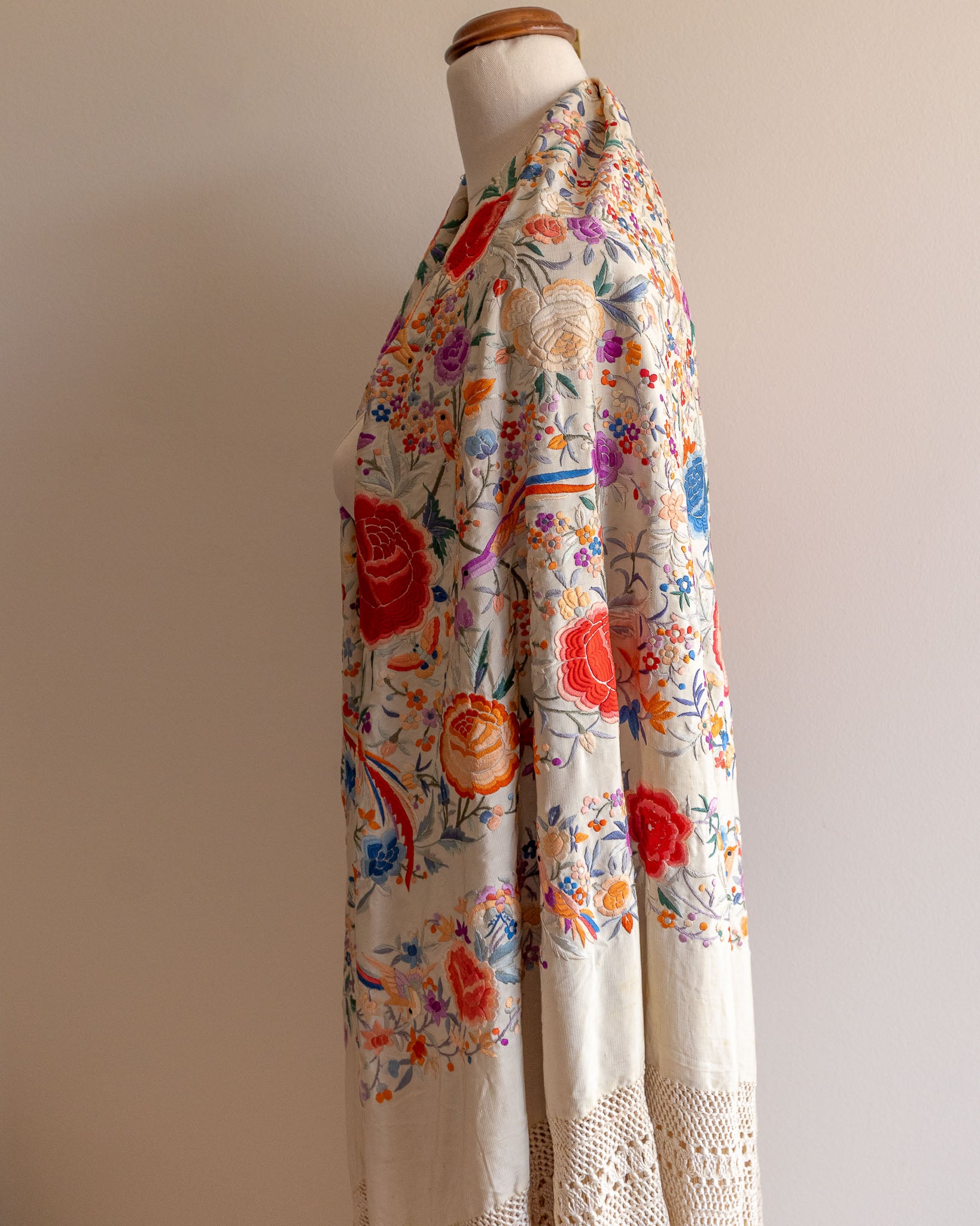 Floral patterned scarf on a mannequin against a plain background